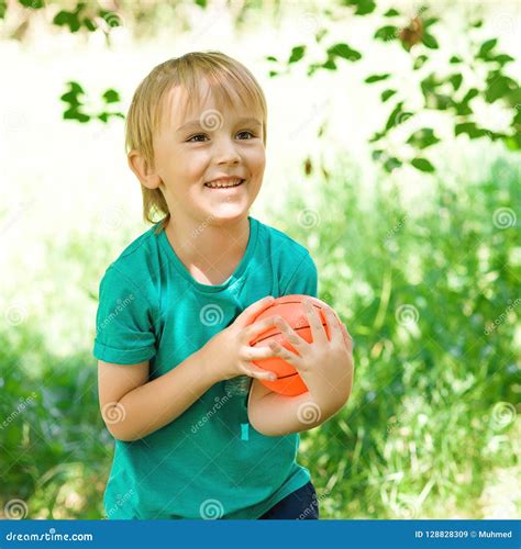 Bambino che gioca all'aperto con una maglietta verde