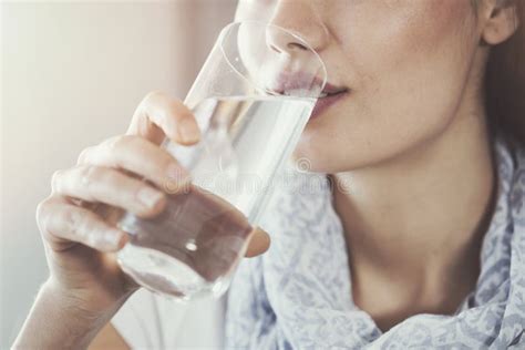 Immagine di una donna incinta che beve un bicchiere d'acqua