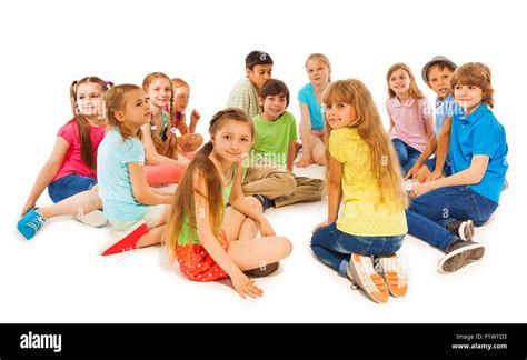 Un gruppo di bambini seduti in cerchio ascolta una narratrice di storie
