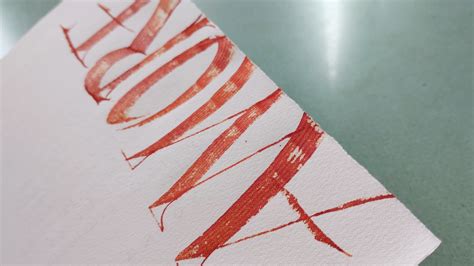 Dettaglio di un biglietto di auguri scritto a mano accanto a una corona d'alloro