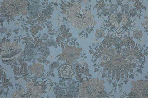 Dettaglio di un tessuto jacquard con motivi floreali su letto in stile provenzale