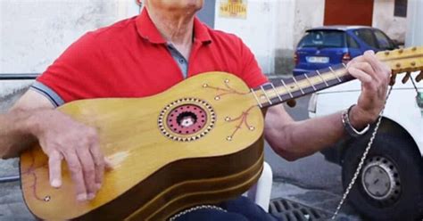 Un musicista che suona la chitarra battente, strumento tipico della tradizione calabrese