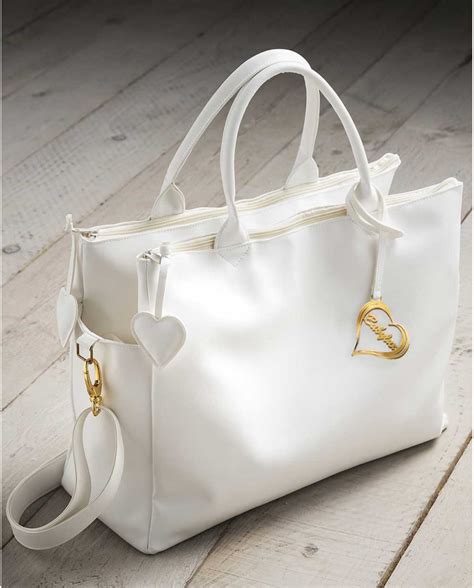 Borsa Nanàn bianca in ecopelle dal design elegante e trapuntato poggiata su un passeggino