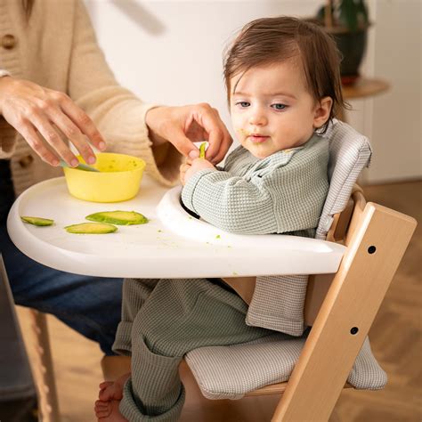 Bambino di circa 1 anno che mangia su una Stokke Tripp Trapp con baby set
