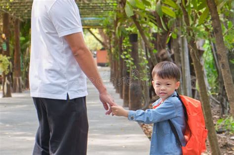 genitore che sorride mentre porta il proprio bambino, entrambi visibilmente a loro agio