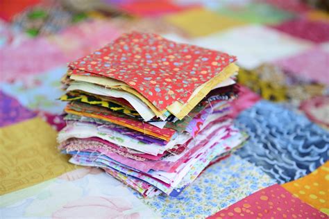 una coperta patchwork realizzata con vecchi indumenti colorati disposti in quadrati ordinati