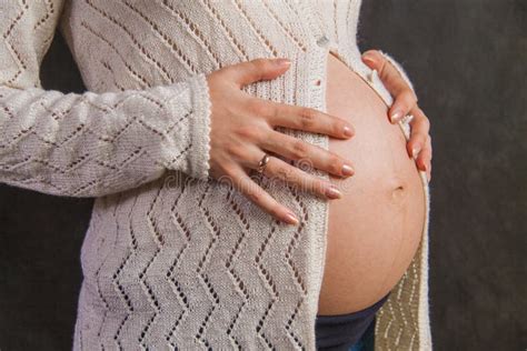Donna incinta che si massaggia la pancia con olio