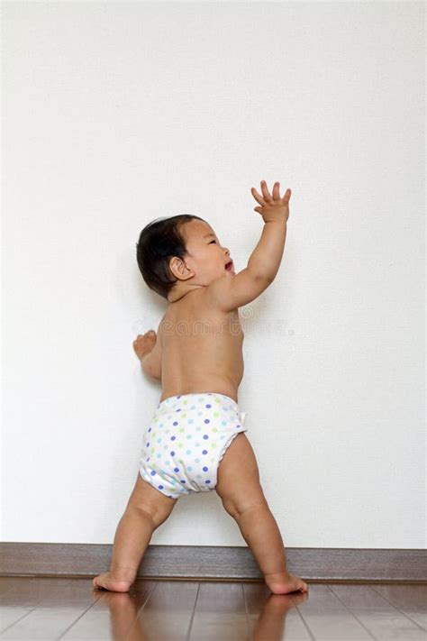 bambino che si alza in piedi aggrappandosi a un mobile