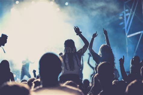 Pubblico a un concerto con braccia alzate