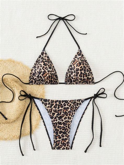 una selezione di costumi estivi da neonata disposti ordinatamente su una coperta da spiaggia