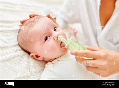 Bambino con naso congestionato e aspiratore nasale