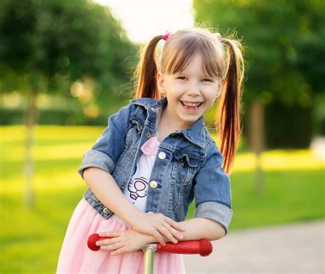 Bambina di 3 anni che prova una bicicletta in un parco