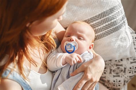 Dettaglio di un neonato che succhia un ciuccio ortodontico
