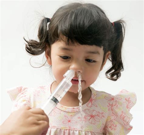 bambino che fa lavaggio nasale