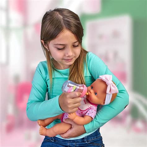 Nenuco doll with bottle and clothes playing with a child