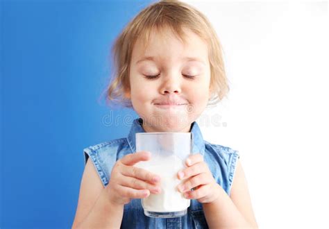 Bambino che beve da un bicchiere con manici sotto la supervisione di un adulto