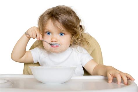 Bambino che mangia la pappa con un cucchiaio
