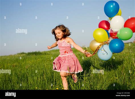 bambina che gioca con palloncini rossi