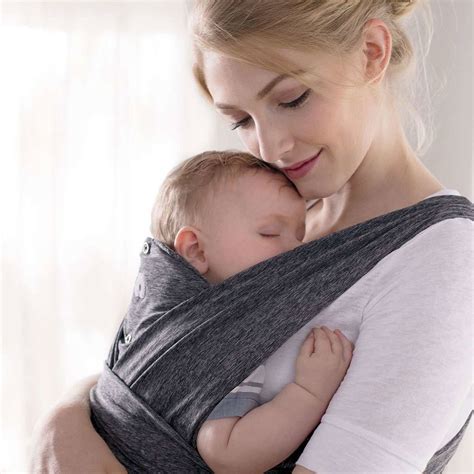 Coppia che passeggia con un neonato nel Boppy ComfyFit portabebè blu