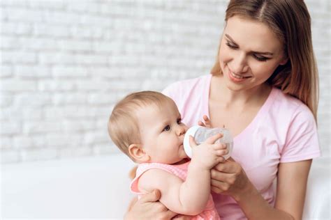 Genitore che alimenta il bambino con il biberon con tecnica corretta