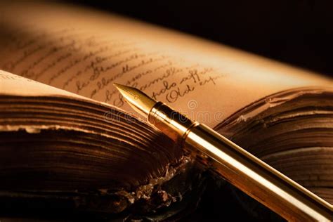 Un vecchio libro di poesie aperto con una penna accanto, su un tavolo di legno