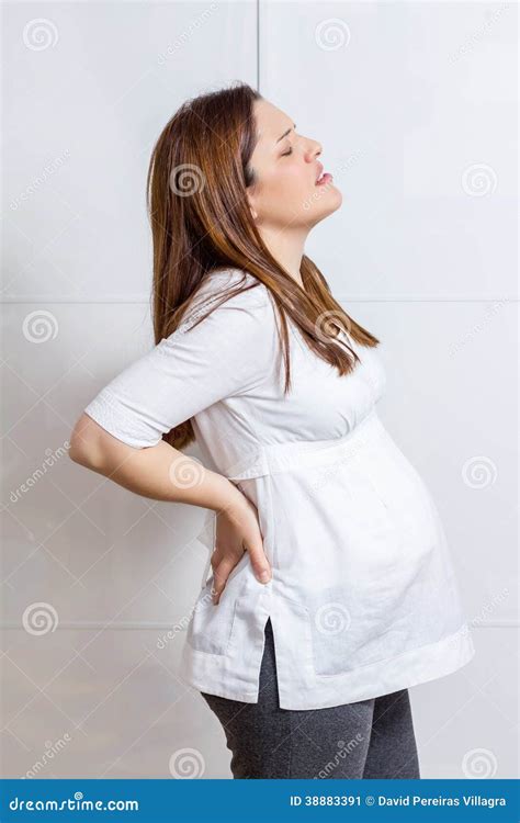 Donna incinta che massaggia la pancia con olio di mandorle