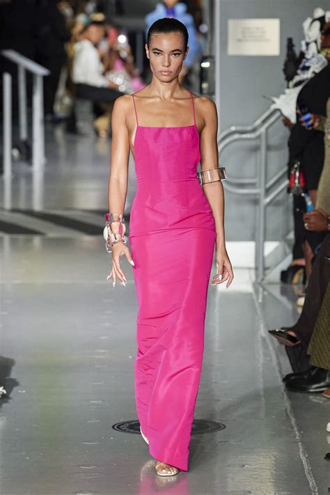 Modella che indossa una tutina in raso fucsia in un ambiente urbano serale
