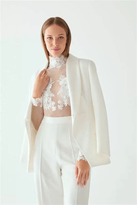 Modella che indossa un corpetto da sposa in pizzo abbinato a pantaloni in jeans e giacca in pelle