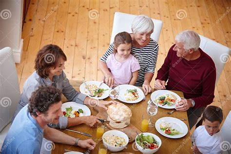 Famiglia che condivide un pasto sano, con il bambino che assaggia dal piatto dei genitori