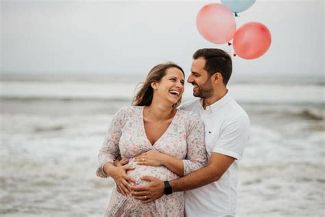 Una giovane coppia sorridente che annuncia la gravidanza alle rispettive famiglie