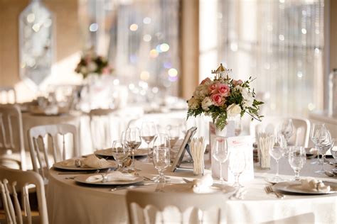 Una tavola elegante preparata per un ricevimento di battesimo con fiori bianchi e dettagli minimalisti
