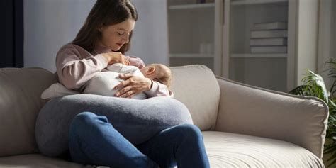 Mamma che allatta con cuscino