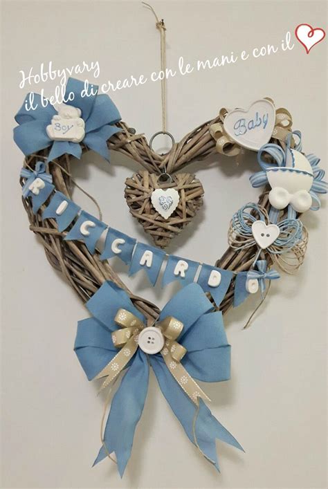 Un elegante fiocco nascita a forma di cuore in vimini appeso a una porta bianca decorata