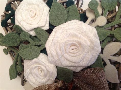 Dettaglio ravvicinato della rosa in piquet e dei rametti di feltro su base di vimini