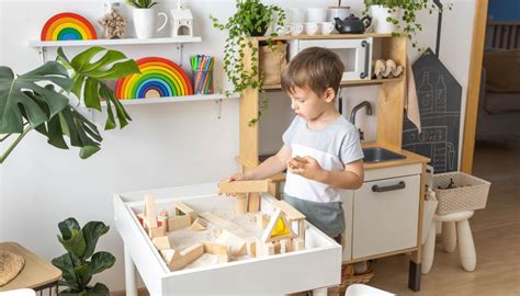 Bambino che abbina carte Montessori di oggetti e stanze
