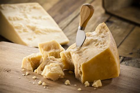 Una selezione di scaglie di Parmigiano Reggiano su un tagliere di legno