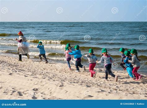 Bambini che corrono in spiaggia indossando ciabatte Nike