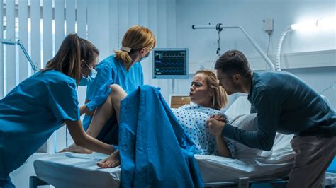 Una donna che spinge durante il parto con il supporto di un'ostetrica
