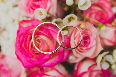 fotografia simbolica di un mazzo di fiori e fedi nuziali
