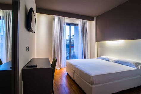 Interno di una camera standard presso l'hotel con balcone e arredamento funzionale