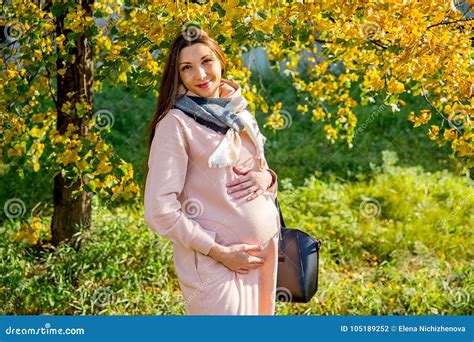 Donna incinta che cammina in un parco