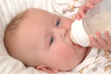 Bambino che succhia il biberon felice