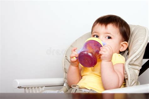 Bambino che impara a bere dalla tazza