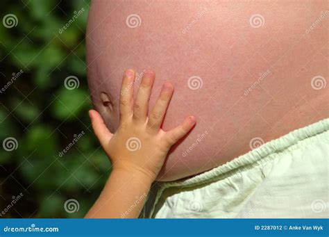 Bambino che tocca la pancia della mamma in gravidanza