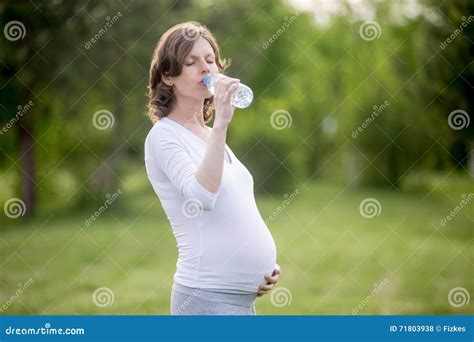 Donna incinta che beve acqua