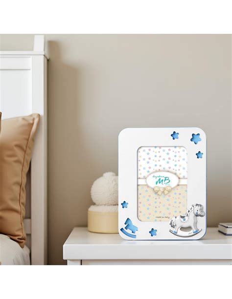Nursery arredata con cornice nascita in legno, creando un ambiente caldo e personale