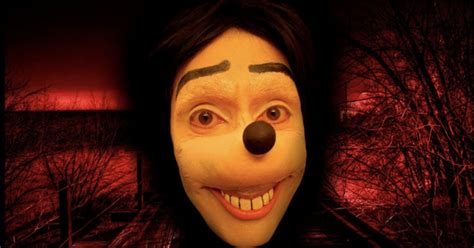 Un'immagine stilizzata di Jonathan Galindo con le sembianze di Pippo, che emerge da uno schermo di computer o smartphone con uno sfondo oscuro che suggerisce pericolo.