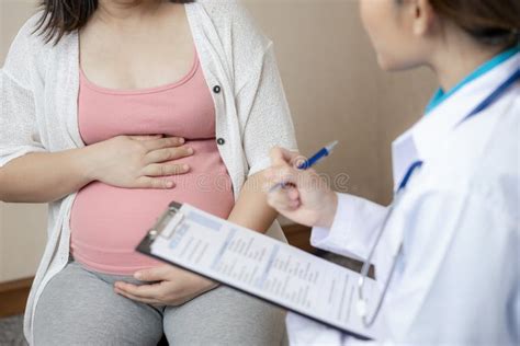 Donna incinta e ginecologo, discutendo una diagnosi