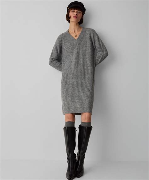 donna con abito grigio e accessori chiari