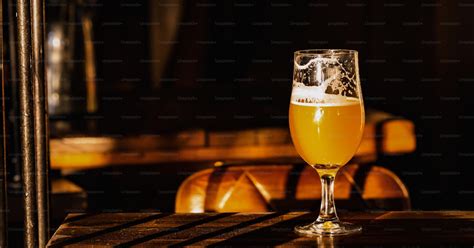 Un boccale di birra in vetro poggiato su un tavolo di legno